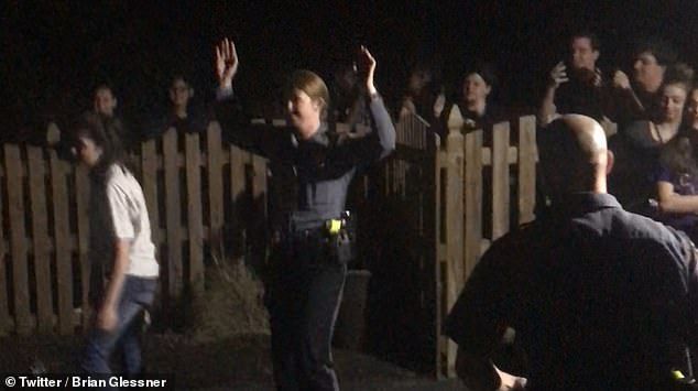 While one officer speaks to the host of the party the others join in a game of basketball outside