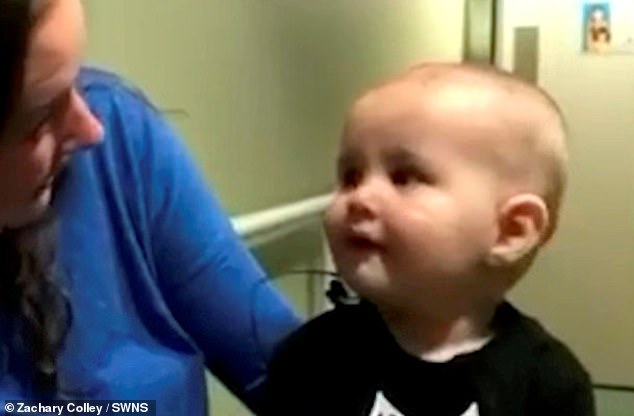 The young boy, who qualified for cochlear implant surgery, looks at his mother Ashley as she speaks to him