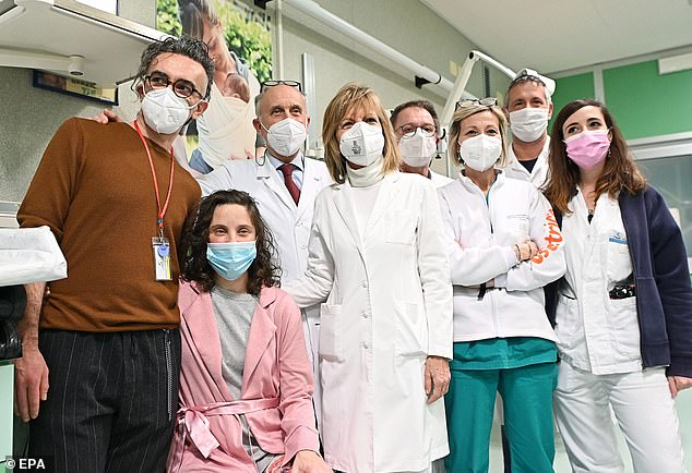 Ten medics ended up operating on Teresa (left, with husband Francesco in brown) simultaneously to fix the lesion and deliver her baby - a daughter - by Cesarean section