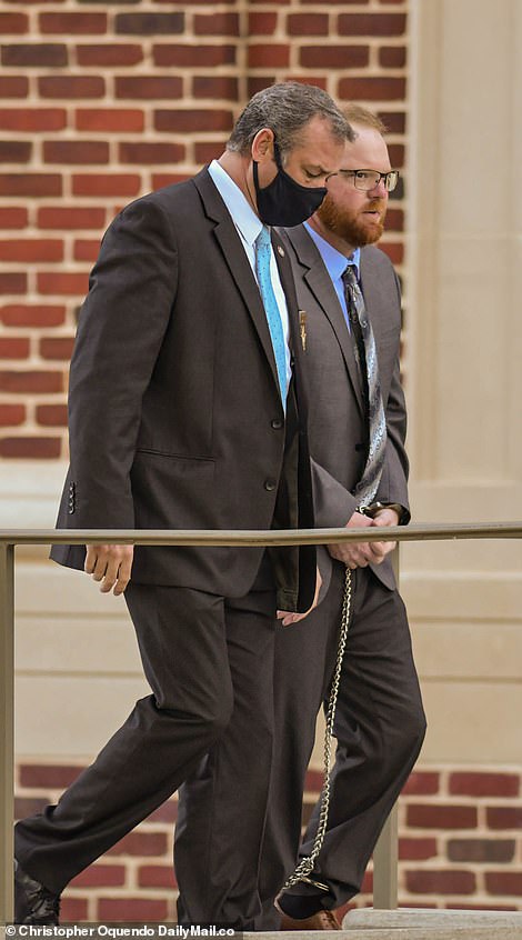 Travis McMichael, 35, arrives in court in shackles on Friday morning to be sentenced for the murder of Ahmaud Arbery. He will be at least 65 before he gets out of prison