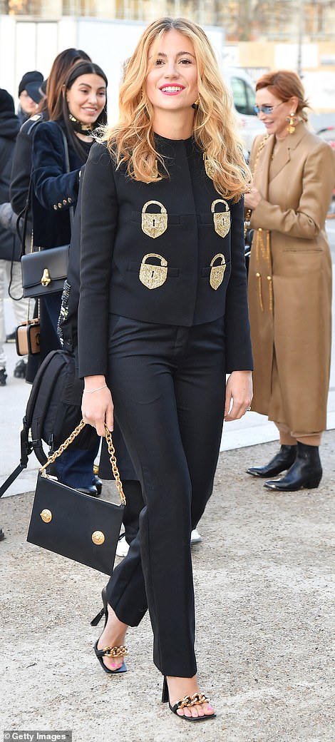 Striking: Also at the Schiaparelli show was Pixie Lott who wowed in a black blazer adorned with a glittering gold padlock design that she paired with tapered trousers