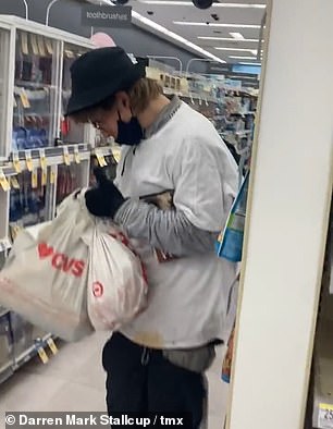 The shoplifter slowly saunters away, looking at the stolen goods in his bag