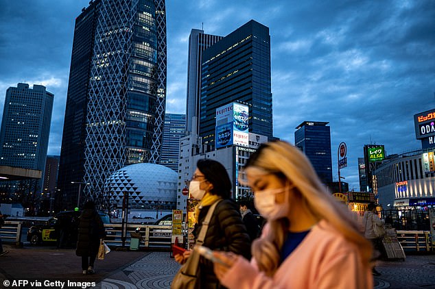 Pedestrians walk in the Shinjuku district of Tokyo as the city and a number of regions across the country earlier this month were placed under partial Covid-19 restrictions