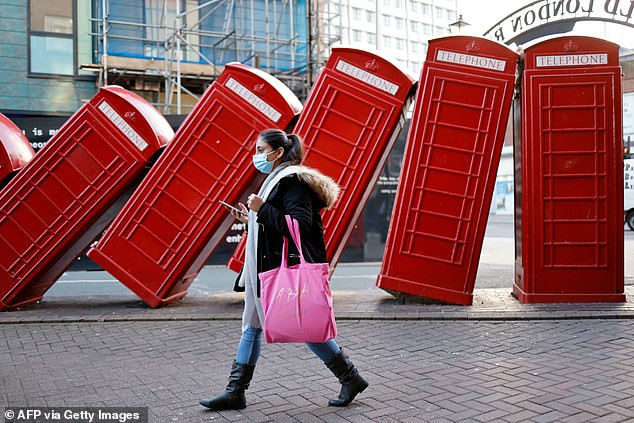 A shopper in a face mask walks in Kingston-upon-Thames in south-west London. Mandatory masks are no longer required in public places in England