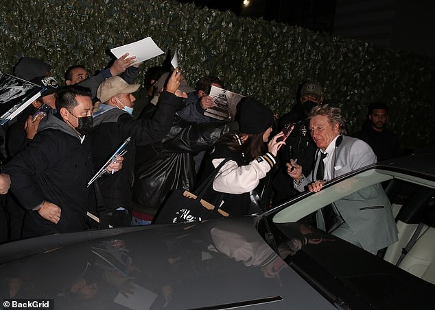 Adoring fans: The hitmaker wielded a black Sharpie as he signed autographs before getting into the front passenger seat of a Rolls-Royce