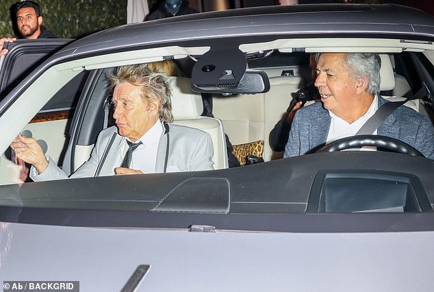 Night out: The rock star looked typically dapper in a light grey suit with trimmed lapels which he teamed with a black tie and white shirt