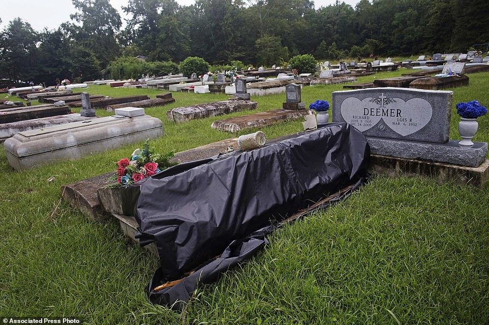 A flood damaged tomb is covered for repair at the cemetery of Greater St. Mark Baptist Church in Walker