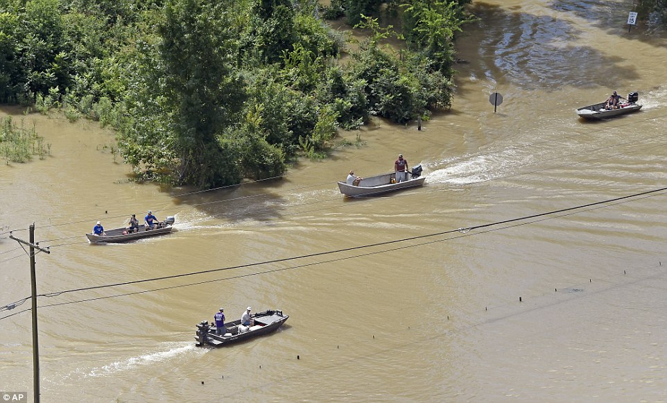 Boats sail on Highway 431, flooded after heavy rains in the Ascension Parish area, south of Baton Rouge on Tuesday