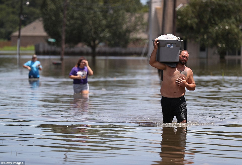 Clint Guedry carries a container full of items he retrieved from his girlfriends flooded home on Wednesday in Sorrento