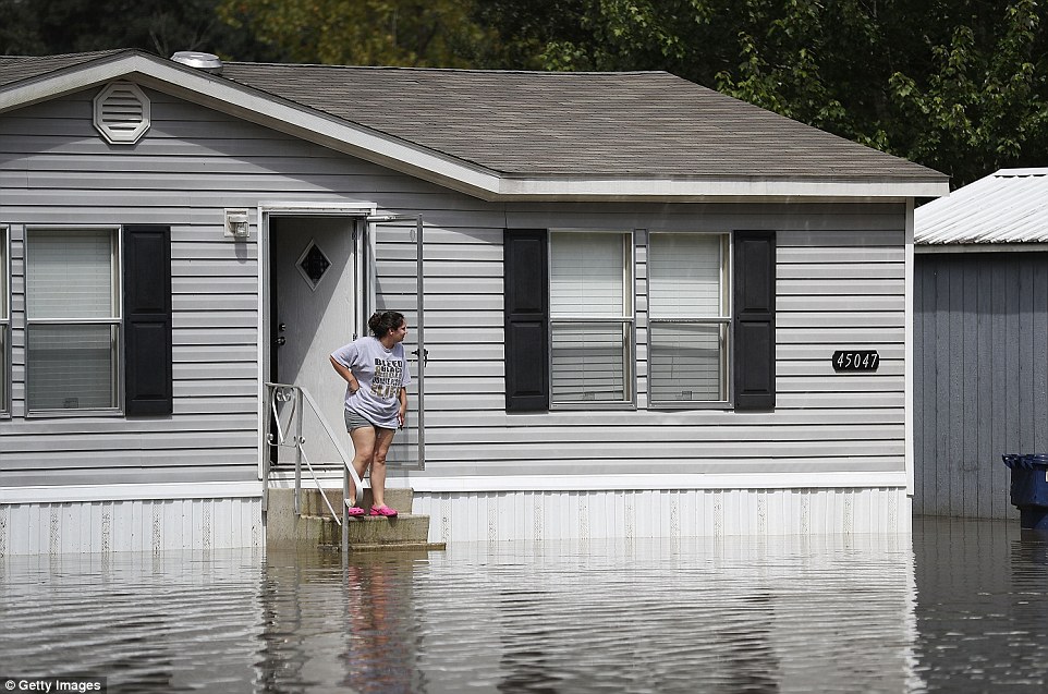 A woman stands on the steps of her Sorrento home surrounded by flood waters on Wednesday