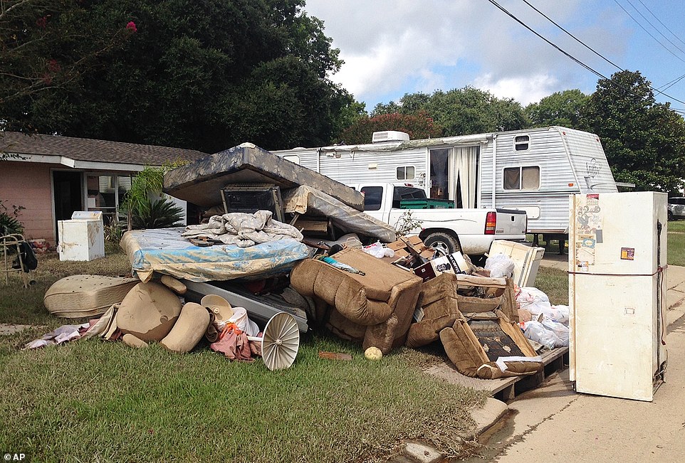 A growing pile of debris sits outside the flood-ravaged home of Carolyn and James Smith in Denham Springs on Wednesday. Smith said she and four other adults will live for the time being in the travel trailer that one of her sons towed to the driveway after weekend flooding inundated the area