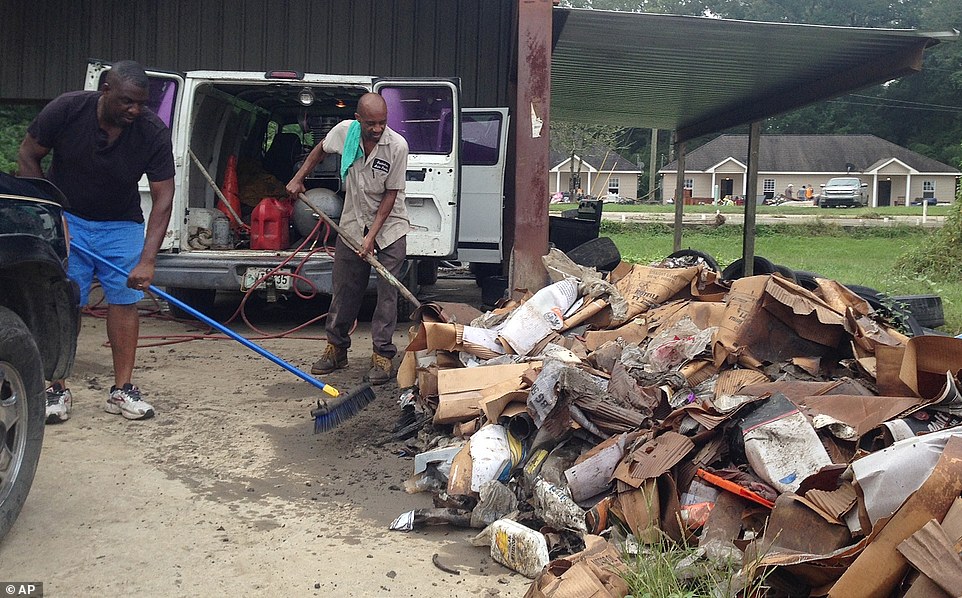 Terry Brewer, left, and Timothy Harris pile up debris outside a flooded auto parts store in Albany on Wednesday. The U.S. Small Business Administration plans to open several south Louisiana locations to help businesses damaged by record flooding