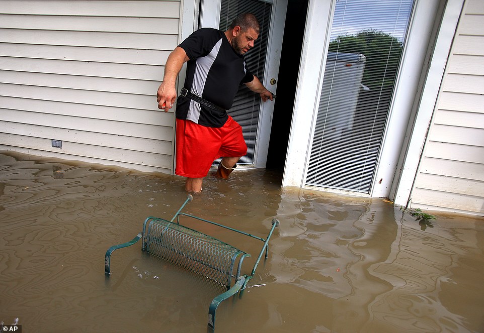 Wade Gary exits his home after viewing the damage in his studio apartment from floodwater  in Abbeville