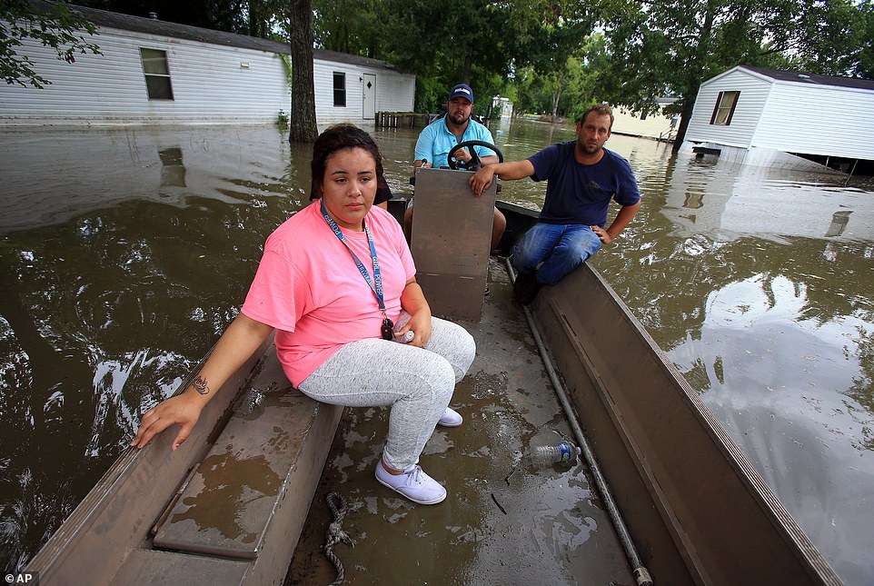 Jasmine Fontenot, front, gets a boat ride to her home with the help of Darius Girouard, back, and Fabian LeBlanc after her family was evacuated do to high water from recent rain
