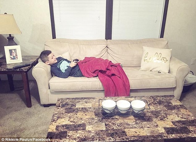 Gender equality: Nikkole, who said he likes to relax after his chores by playing video games, pictured, said she is teaching him that housework is 'not just for women'